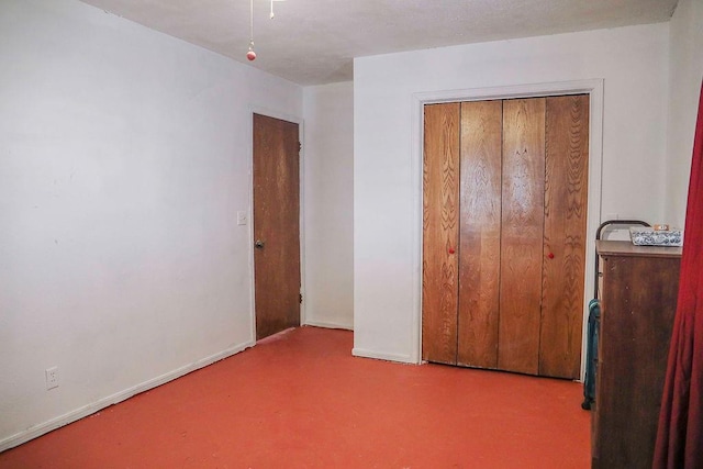 unfurnished bedroom with baseboards and a closet