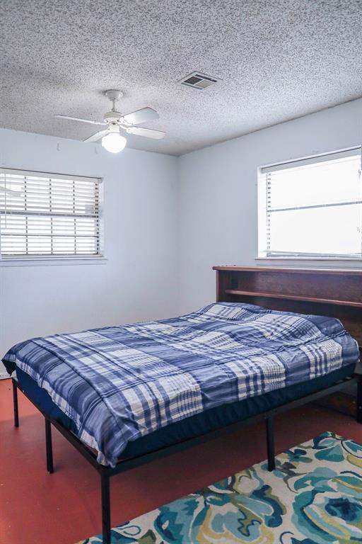 bedroom with visible vents, ceiling fan, and a textured ceiling