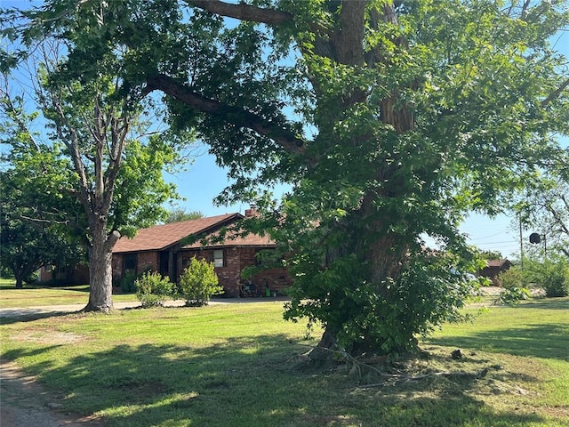 114 N Rambo St, Dill City, OK 73641 - view of front of home featuring a front lawn and a chimney