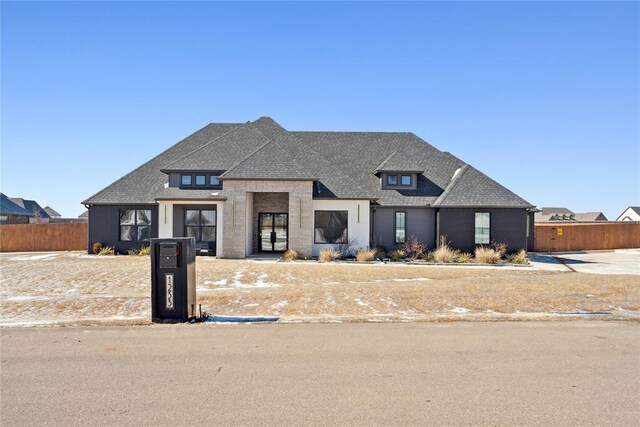 view of front of home featuring fence and roof with shingles