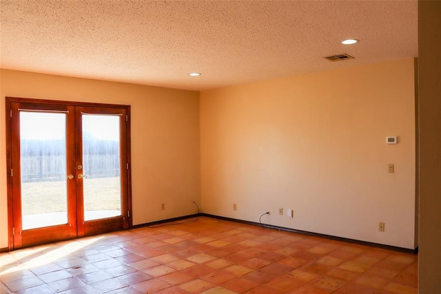 spare room featuring french doors and a textured ceiling