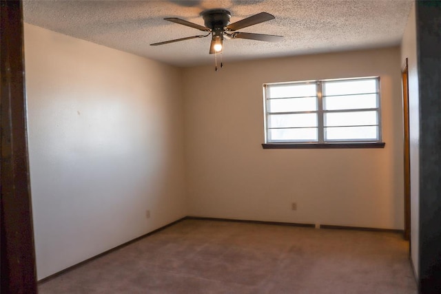 spare room featuring ceiling fan, carpet flooring, and a textured ceiling