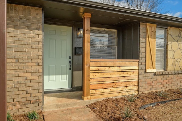 entrance to property featuring brick siding