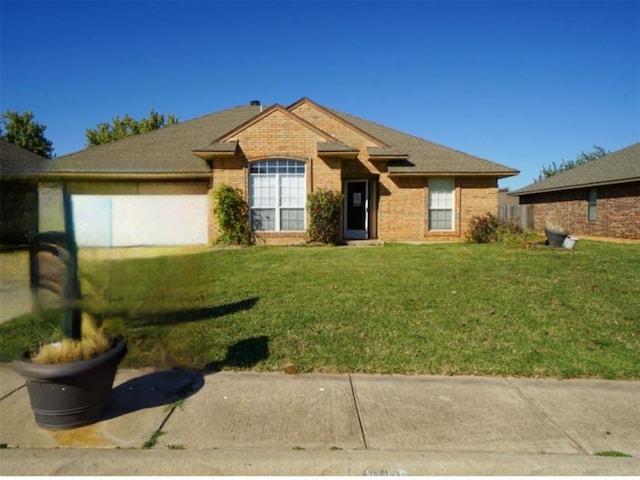 single story home featuring brick siding, an attached garage, and a front lawn