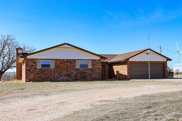 ranch-style house with driveway, a garage, and brick siding