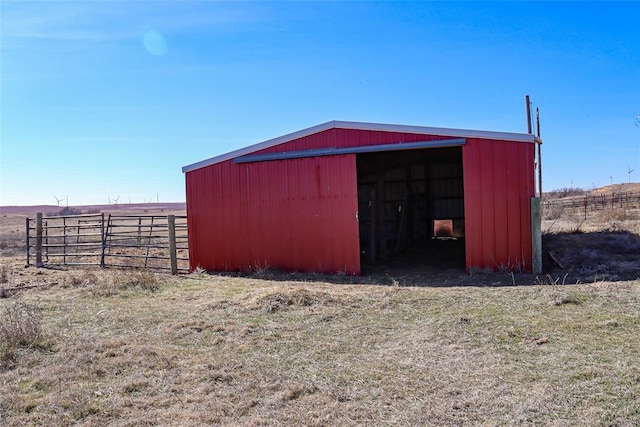 view of pole building with a rural view and fence