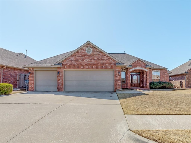 view of front of property with roof with shingles, concrete driveway, and brick siding