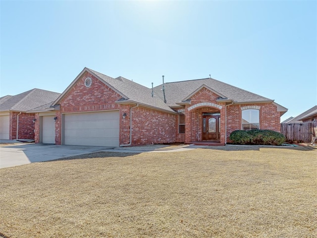 ranch-style house featuring an attached garage, fence, a front lawn, and brick siding