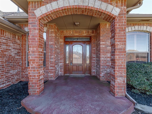 entrance to property with brick siding and visible vents