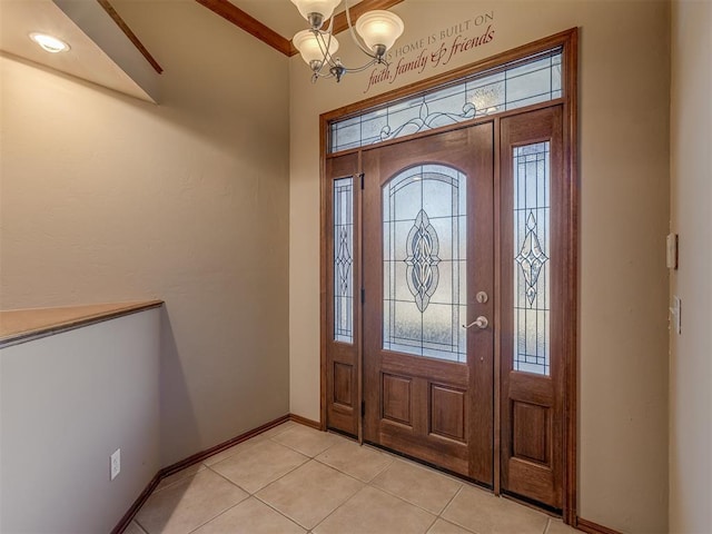 foyer entrance with light tile patterned flooring, plenty of natural light, baseboards, and an inviting chandelier