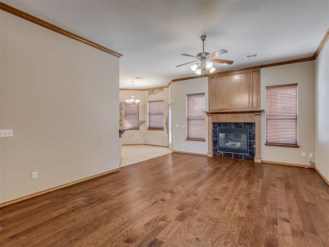 unfurnished living room featuring a premium fireplace, light wood-type flooring, visible vents, and crown molding