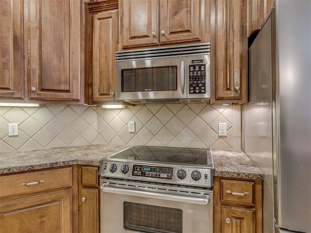 kitchen with stainless steel appliances, brown cabinetry, and backsplash