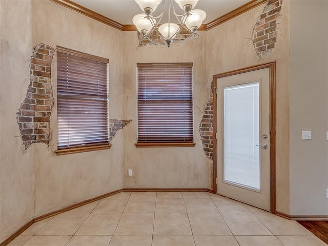 spare room featuring tile patterned flooring, a notable chandelier, baseboards, and crown molding