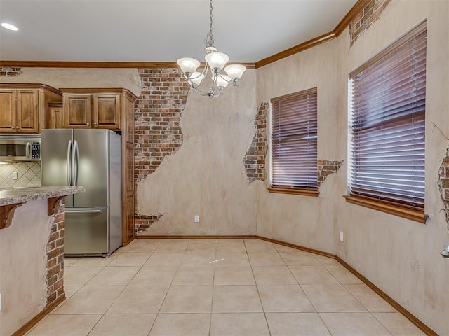 unfurnished dining area with light tile patterned floors, baseboards, a chandelier, and crown molding