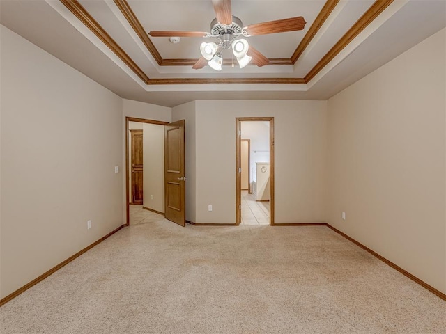 unfurnished bedroom featuring a tray ceiling, light colored carpet, and ornamental molding