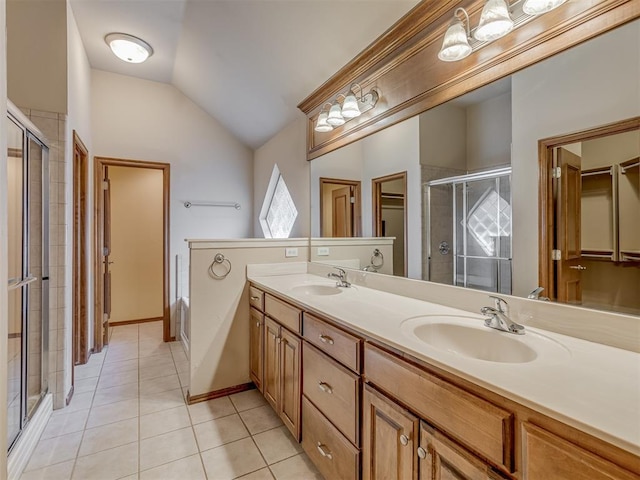 bathroom featuring tile patterned flooring, vaulted ceiling, a sink, and a shower stall