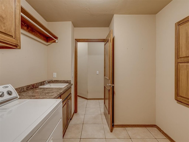 laundry room featuring washer / dryer, cabinet space, a sink, and light tile patterned flooring