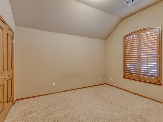 interior space featuring lofted ceiling, carpet floors, baseboards, and visible vents