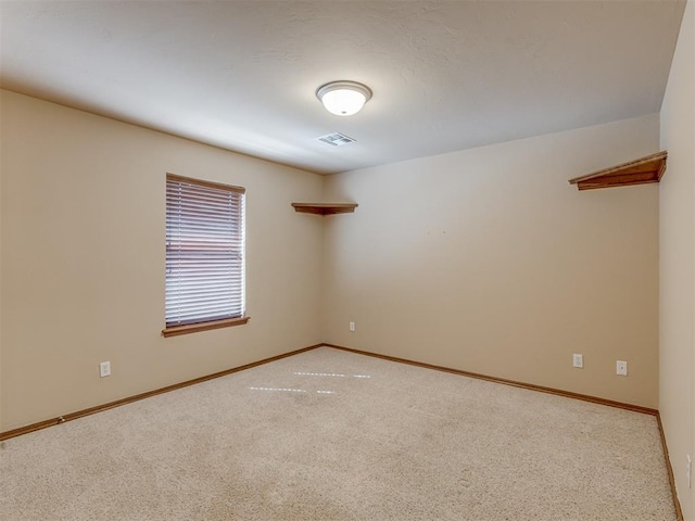 unfurnished room featuring carpet, visible vents, and baseboards