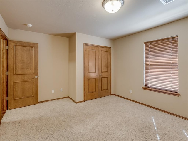 unfurnished bedroom with light carpet, baseboards, and a closet