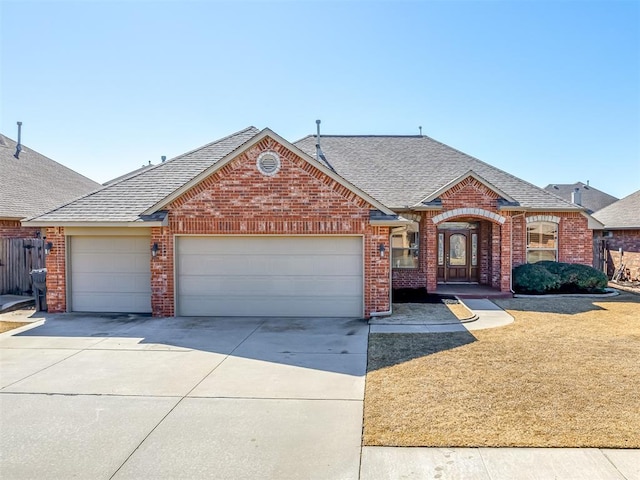 view of front of property with an attached garage, brick siding, driveway, roof with shingles, and a front lawn