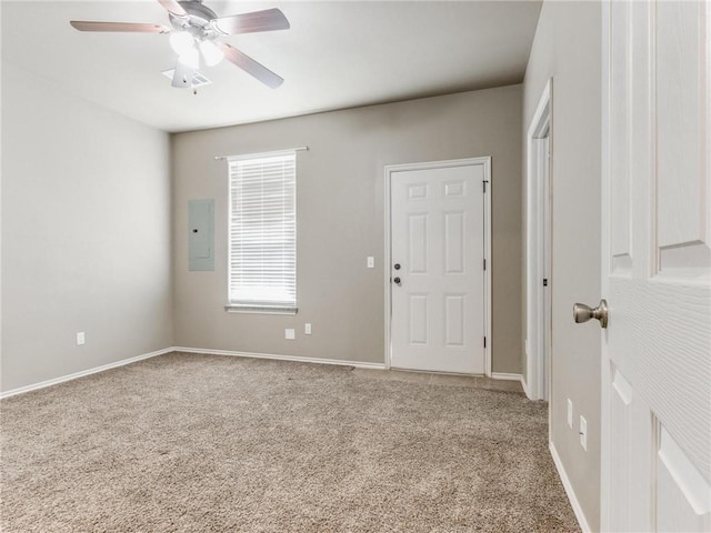 empty room with electric panel, ceiling fan, and carpet flooring