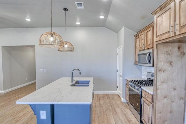 kitchen with visible vents, light stone countertops, light wood-style floors, stainless steel appliances, and a sink