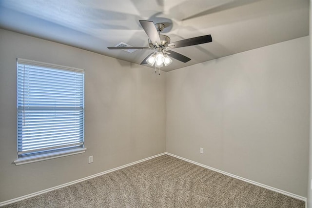 carpeted empty room featuring a ceiling fan and baseboards