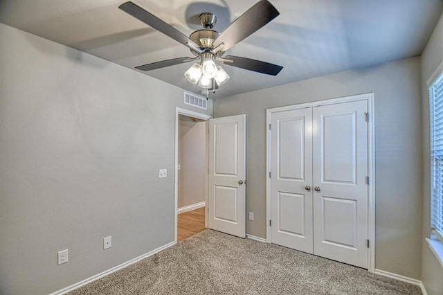 unfurnished bedroom with visible vents, baseboards, light colored carpet, and a closet