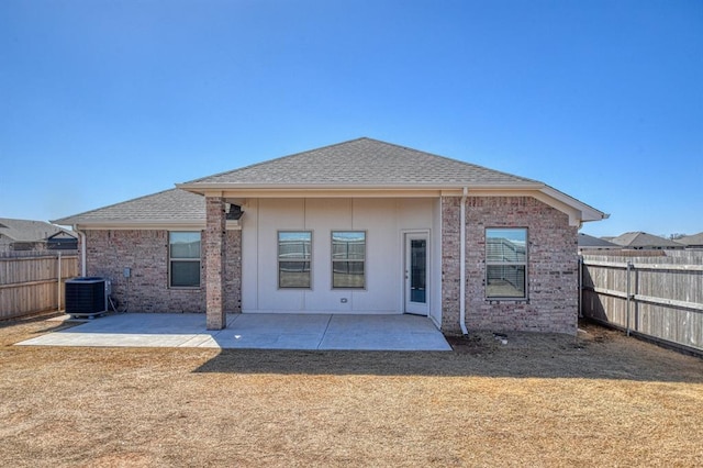 rear view of property with a patio, a fenced backyard, brick siding, and a shingled roof