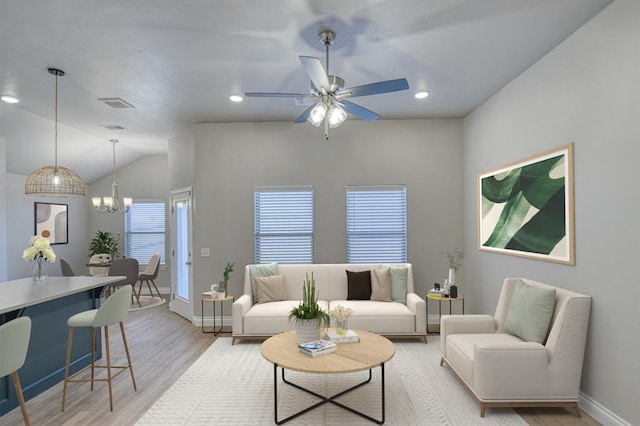 living room with visible vents, baseboards, recessed lighting, light wood-style flooring, and ceiling fan with notable chandelier