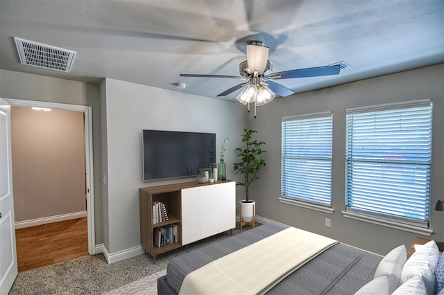 bedroom with visible vents, carpet floors, baseboards, and a ceiling fan