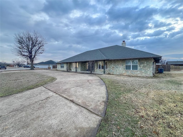 single story home featuring central AC unit and a front yard