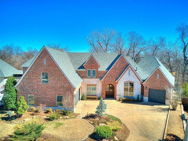 view of front of property with driveway, a garage, and brick siding