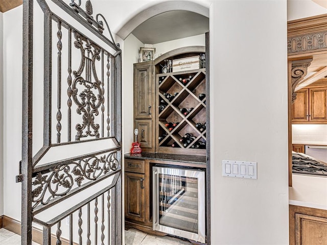 wine cellar with arched walkways and beverage cooler