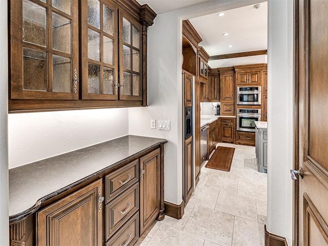 kitchen with dark countertops, glass insert cabinets, stainless steel double oven, and recessed lighting