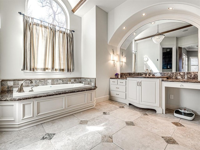 bathroom featuring baseboards, vanity, a bath, and recessed lighting