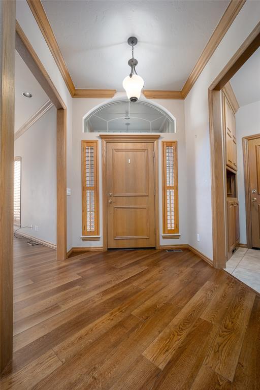1601 Vandivort Pl, Edmond, OK 73034 - entrance foyer with ornamental molding, light wood-style flooring, and baseboards