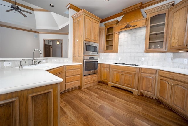 1601 Vandivort Pl, Edmond, OK 73034 - kitchen featuring stainless steel appliances, a ceiling fan, a sink, light wood-style flooring, and decorative backsplash