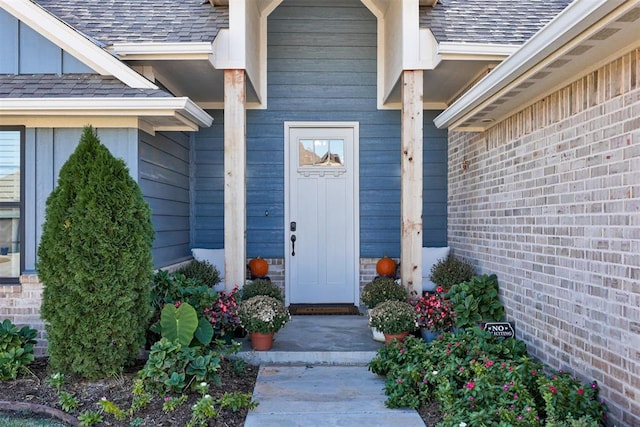 entrance to property with brick siding and roof with shingles