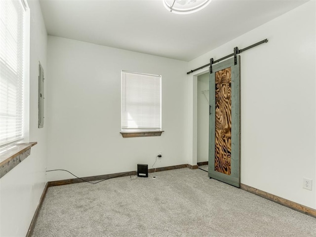 empty room with light carpet and a barn door