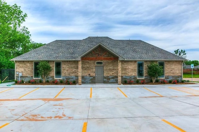 view of front of home featuring a shingled roof and brick siding