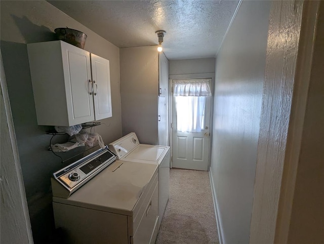 washroom featuring cabinet space, separate washer and dryer, and a textured ceiling