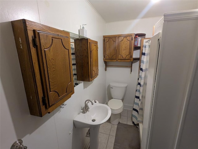 full bathroom featuring crown molding, curtained shower, toilet, a sink, and tile patterned flooring