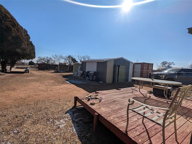 exterior space featuring an outbuilding, fence, and a deck