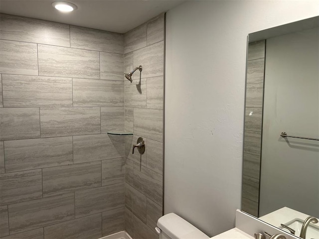 bathroom featuring tiled shower and toilet