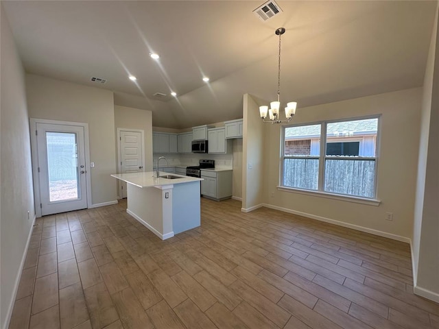 kitchen featuring stainless steel appliances, light countertops, a sink, and visible vents