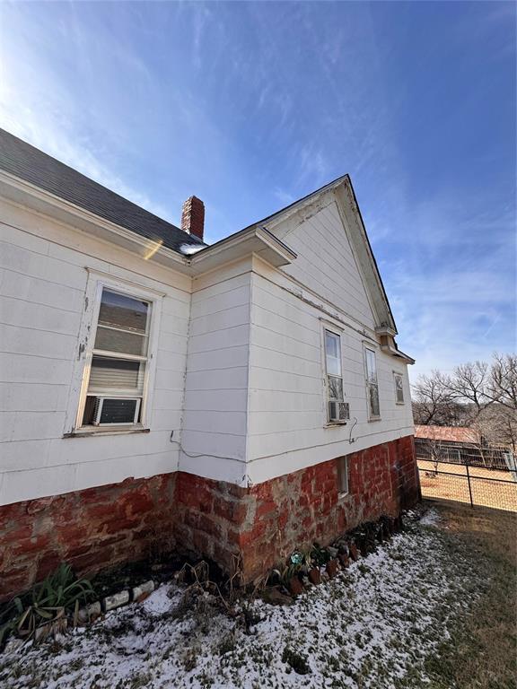 view of property exterior with a chimney and fence