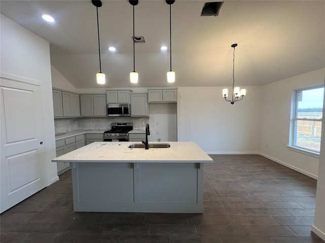 kitchen featuring vaulted ceiling, appliances with stainless steel finishes, gray cabinets, and a sink