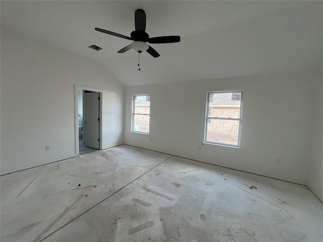 spare room with visible vents, vaulted ceiling, and a ceiling fan